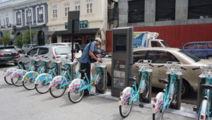 Man gets bike from Penang, Malaysia LinkBike bikeshare station on Beach Street.