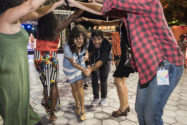 Man and woman walking through other dancers holding up arms