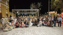 Large group of people smiling with traditional Brazilian dancers