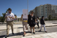 Group of people walk in crosswalk, one using a white tool to view from new perspective