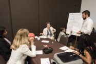 Group of people at large table having meeting and discussing things